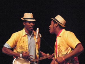 Two students singing into a microphone, wearing costumes