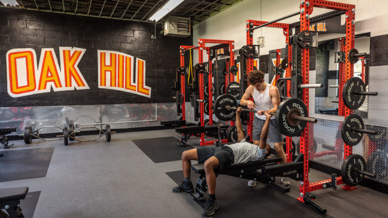 Students spotting each other for bench press in the Oak Hill gym