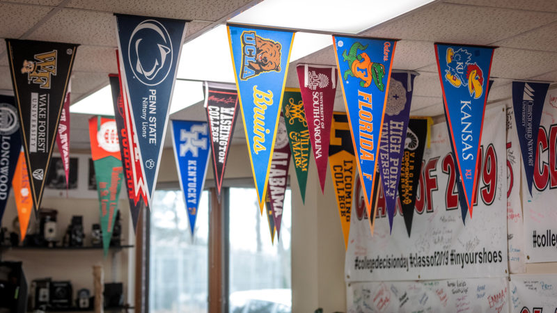Pennants from colleges displayed in rows hanging from ceiling