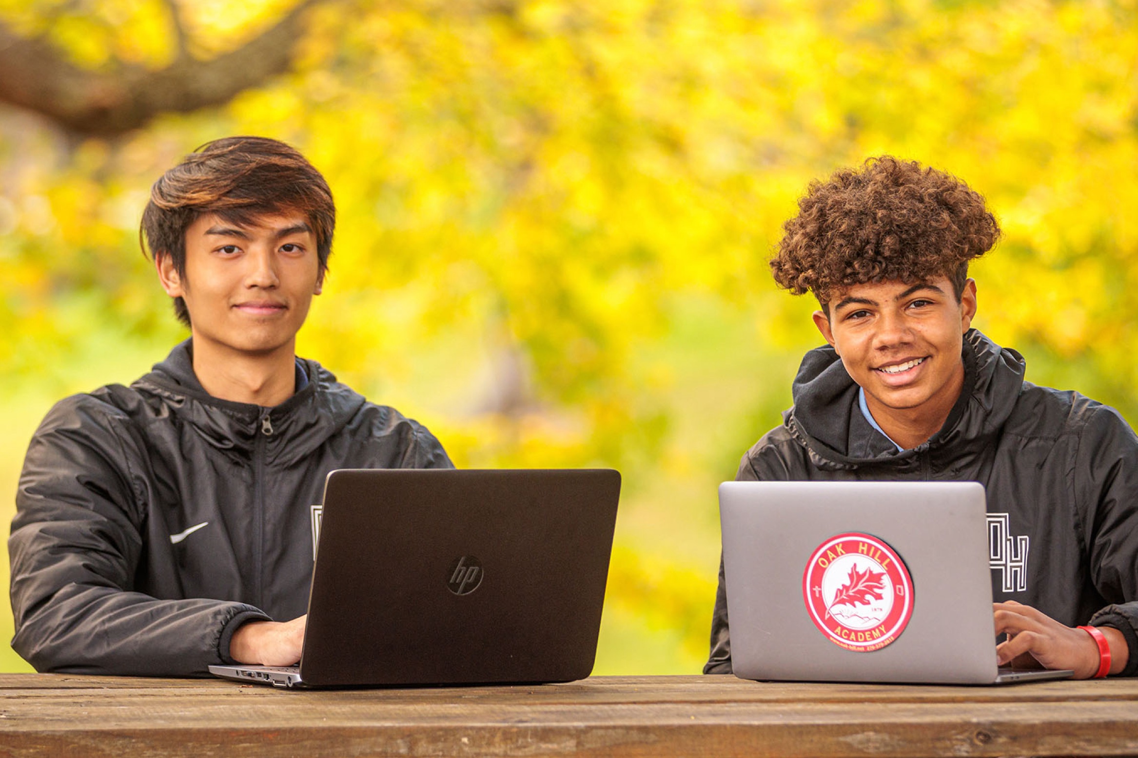 students with laptops outdoors