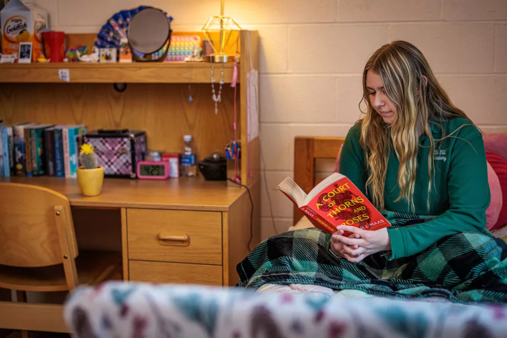 female student with book in dorm